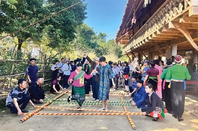 Des touristes visitant le Village culturel et touristique des ethnies du Vietnam. Photo : hanoimoi.vn