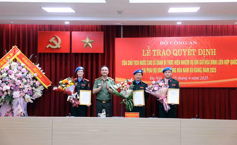 Le vice-ministre de la Sécurité publique, Pham Thê Tùng (2e à partir de la gauche) remet la décision du président de la République aux officiers. Photo: VNA