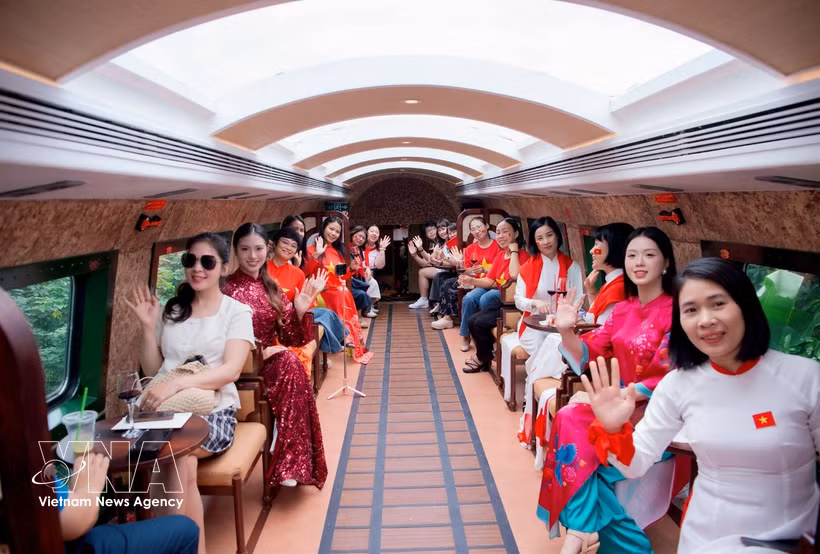 Des visiteurs à bord du Train du patrimoine des Cinq Portes de Hanoi. Photo: VNA