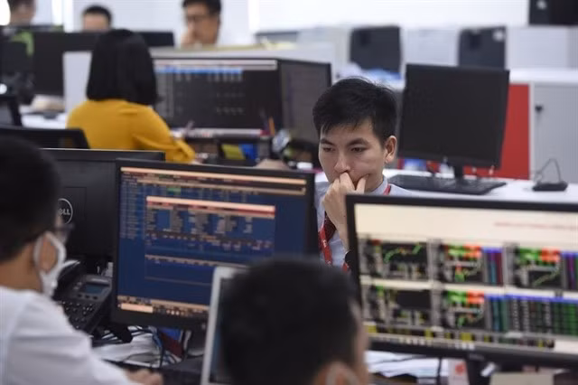 Des traders travaillent dans une salle de marché d'une compagnie de valeurs mobilières à Hanoï. Photo : bnews.vn