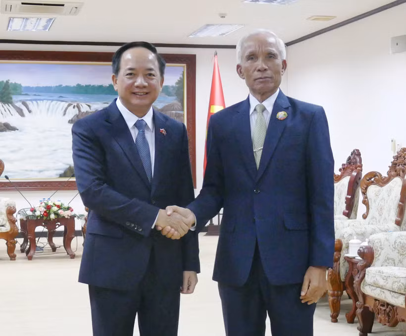 Trinh Van Quyêt (à gauche), secrétaire du Comité central du PCV et chef de sa Commission de la sensibilisation, de l’éducation et de la mobilisation des masses, et Khamphan Pheuiyavong, secrétaire du Comité central du PPRL et président de sa Commission de la propagande et de la formation, se serrent la main, à Vientiane, le 1er décembre. Photo : VNA