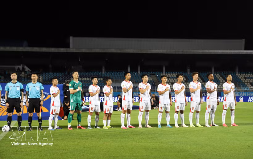 Les joueurs vietnamiens saluent le drapeau et chantent l'hymne national au stade de Chonburi en Thaïlande, avant leur rencontre face aux Est-Timorais. Photo: VNA
