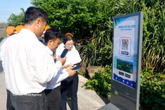 Des visiteurs utilisent un code QR pour consulter les informations touristiques au mât de souveraineté de Phu Quy (Lâm Dông). Photo : VNA.