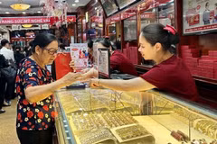 Un client achète des bijoux en or dans une boutique d'or de l'arrondissement de Hai Bà Trung, ​​Hà Nội. Photo VNA