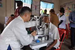 Un médecin examine le fond d’œil d’un habitant cambodgien. Photo : VNA 
