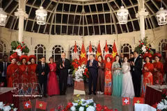 Le secrétaire général du Parti et président de la République, Tô Lâm, et son épouse, Ngô Phuong Ly, ainsi que le président suisse, Guy Parmelin, et son épouse, Caroline Parmelin, offrent des fleurs aux artistes. Photo : VNA.