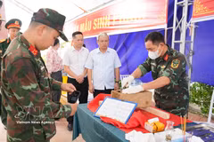 Des cadres et soldats du Commandement militaire de la province de Phu Tho photographient et numérisent les informations relatives aux échantillons de restes de martyrs destinés aux analyses ADN. Photo : VNA