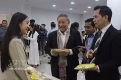 Des délégués découvrent les produits d'entreprises cambodgiennes exposés lors du séminaire. Photo : VNA 