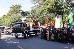 Une foule nombreuse attend le passage du cortège funèbre pour accompagner les restes des héros et martyrs jusqu’au cimetière de la ville, où ils seront inhumés. Photo : VNA