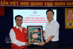 Nguyen Minh Nhut, président de la Croix-Rouge de Hô Chi Minh-Ville, remet un souvenir à Zhao Shi Tang, vice-directeur du Département du travail social du Comité central du Parti communiste chinois. Photo : VNA