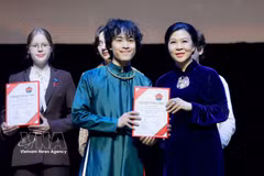 Mme Ngô Phuong Ly, épouse du secrétaire général du Comité central du Parti communiste du Vietnam et président de la République, Tô Lâm, remet des prix aux étudiants ayant obtenu d’excellents résultats. Photo : VNA