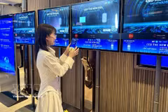 Des entreprises découvrent la plateforme en utilisant la fonction tactile de connexion lors de l’événement. Photo : VNA