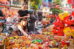 Les touristes étrangers aiment en savoir davantage sur les jouets traditionnels vietnamiens de la Fête de la mi-automne.. Photo : VNA