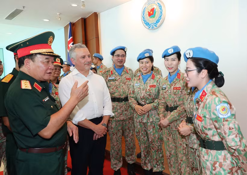 Le général de corps d’armée Hoàng Xuân Chiên, vice-ministre de la Défense et chef du Comité de pilotage du ministère sur la participation aux opérations de maintien de la paix de l’ONU, et Hugh Jeffrey, secrétaire général adjoint à la Défense de l’Australie échangent avec des femmes officiers de la Force vietnamienne de maintien de la paix. Photo : VNA