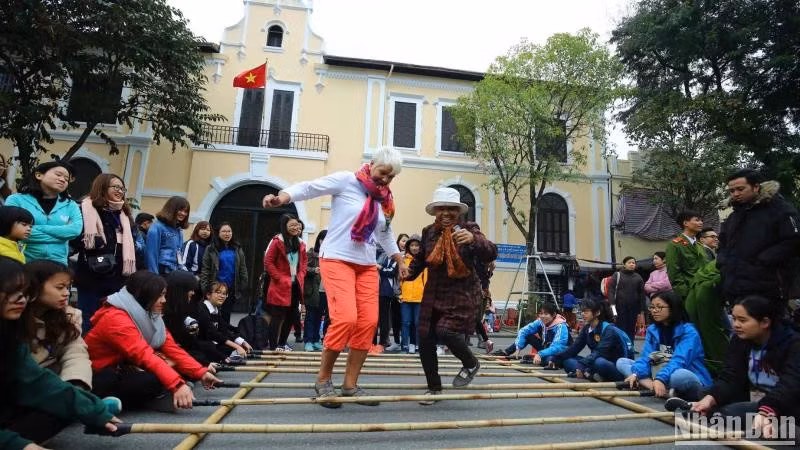 Les visiteurs internationaux découvrent des activités culturelles et des jeux folkloriques à Hanoi. (Photo : Thanh Dat/https://nhandan.vn/)
