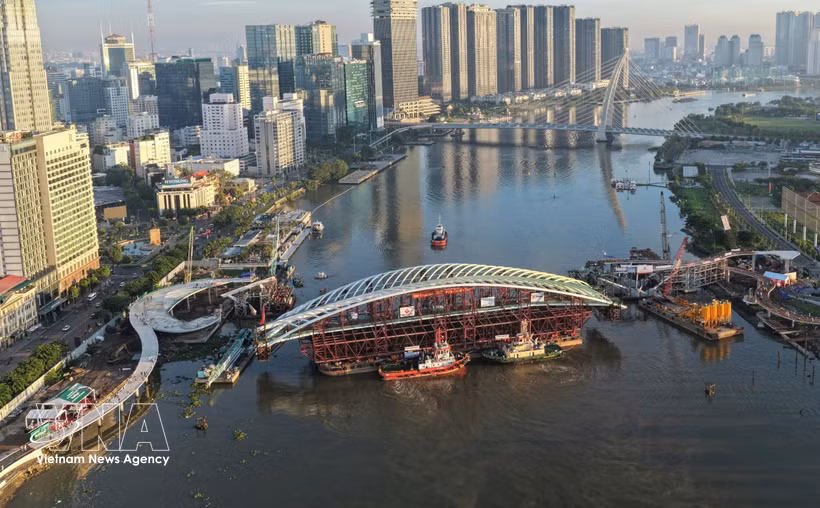 Vue panoramique de la barge transportant la travée principale, mise en place pour l'achèvement du projet de passerelle piétonne enjambant la rivière Saïgon. Photo : VNA