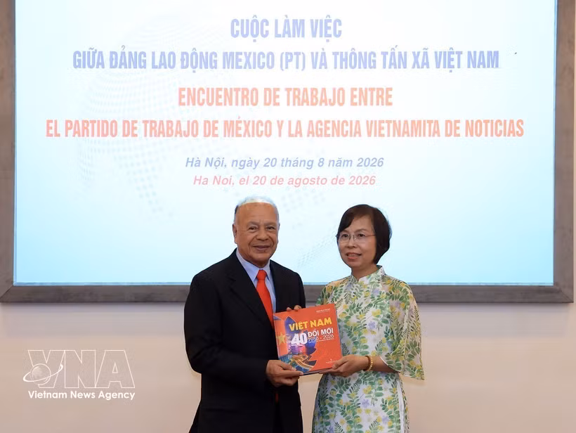 Vu Viet Trang, directrice générale de l'Agence vietnamienne d'Information (VNA), remet un livre de photos à Alberto Anaya Gutierrez, secrétaire général du Parti du travail mexicain. Photo : VNA.