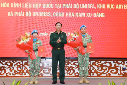Le général de corps d’armée Nguyen Truong Thang, membre du Comité central du Parti et vice-ministre de la Défense (milieu), remet des décisions à deux officiers. Photo: VNA