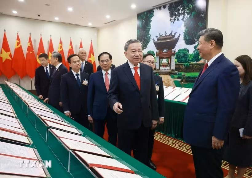 Le secrétaire général du Parti To Lam et le secrétaire général du Parti et président chinois Jinping assistent à la présentation des documents de coopération entre les deux pays. Photo : VNA