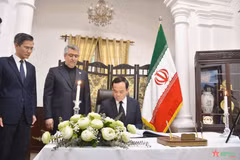Le vice-Premier ministre Tran Luu Quang écrit ses condoléances dans le registre de condoléances à l'ambassade de l'Iran à Hanoï. Photo: VNA