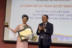 Le ministre vietnamien de la Culture, des Sports et du Tourisme, Nguyen Van Hung, remet la décision de reconduction de Anoa Suzanne Dussol Perran comme ambassadrice du tourisme du Vietnam en France. Photo: VNA