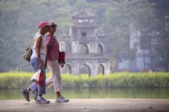 Les touristes étrangers se promènent au bord du lac Hoan Kiem. Photo : VNA