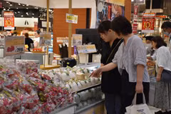 Des consommateurs japonais au stand des fruits vietnamiens. Photo: VNA