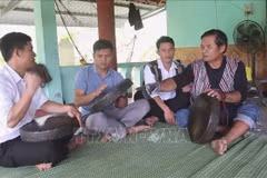 Hà Viêt Sy (à droite) de la commune de Thanh An, district de Minh Long, enseigne à des jeunes Hrê à jouer du gong. Photo : VNA