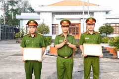 Pham Thanh Tâm, directeur adjoint du Département provincial de la sécurité publique de Long An remet les certificats de mérite du ministère de la Sécurité publique à deux policiers. Photo : VNA