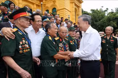 Le président Tô Lâm avec la délégation des personnes ayant rendu des services méritoires à la révolution, à Hanoi, le 22 juillet. Photo: VNA