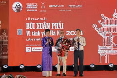 La directrice générale de l’Agence vietnamienne d’information (VNA) Vu Viêt Trang (à gauche) et le vice-président du Comité populaire de Hanoi Hà Minh Hai (à droite) remettent le Grand Prix du Prix «Bui Xuân Phai - Pour l’amour de Hanoi» à l’architecte Hoàng Dao Kinh, à Hanoi, le 8 octobre. Photo : VNA