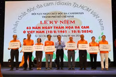 Des responsables du Front de la Patrie du Vietnam à Hô Chi Minh-Ville remettent des bourses d'études aux représentants des enfants victimes de l’agent orange. Photo: VNA 