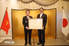 Hoang Binh Quan (gauche), ancien président de la Commission centrale des relations extérieures du Parti communiste du Vietnam (PCV), a reçu l'Ordre du Soleil levant, Grand-Croix de la première classe du Japon lors d'une cérémonie tenue le 15 décembre à Hanoï. Photo: VNA