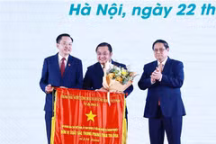 Le Premier ministre Pham Minh Chinh offre le drapeau d'émulation au Groupe chimique du Vietnam (Vinachem). Photo : VNA