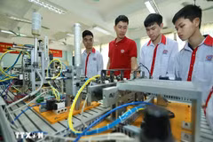 Présentation de modèles d'automatisation aux étudiants de la classe d'électronique industrielle K13 du Collège professionnel de haute technologie de Hanoi. Photo : Hoang Hieu/VNA