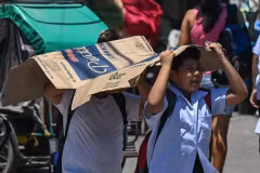 Des étudiants utilisent un carton pour se protéger du soleil lors d'une chaude journée à Manille le 2 avril 2024. (Photo : philstar.com)