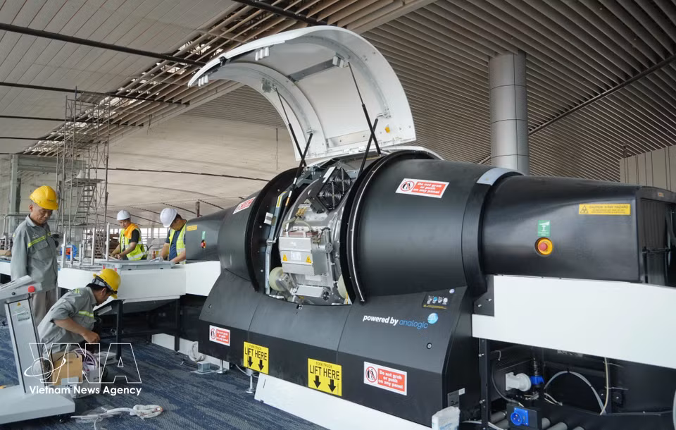 Des ouvriers vérifient et installent les composants des scanners 3D pour bagages à main. Photo : VNA