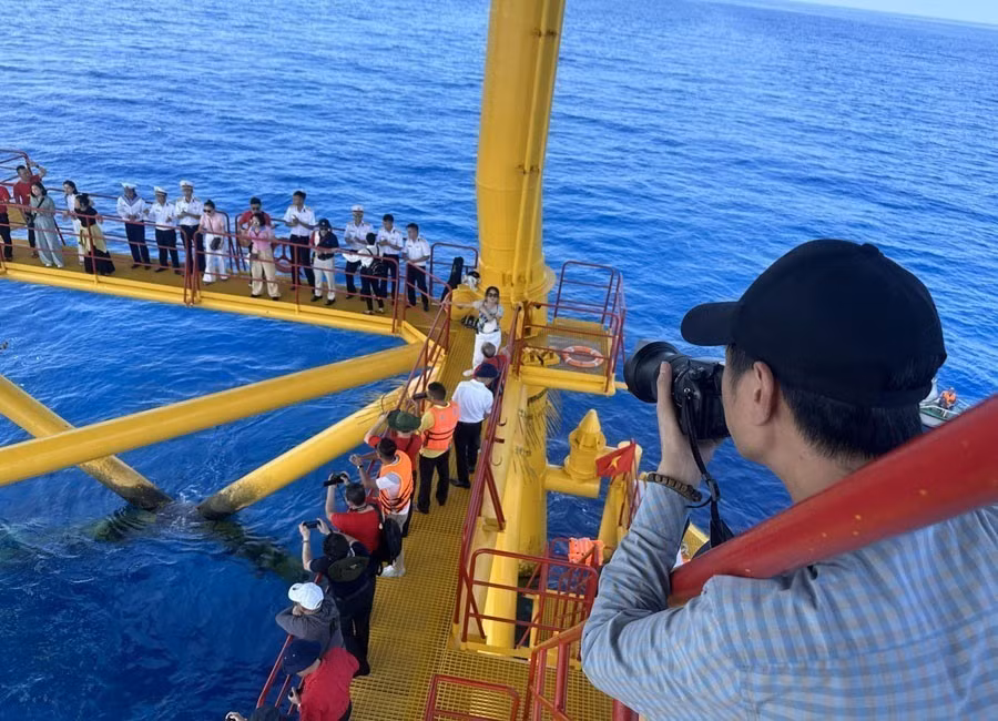Des journalistes capturent un moment d’échange sur la plateforme DK1 Phuc Tân en 2023. Photo : VNA
