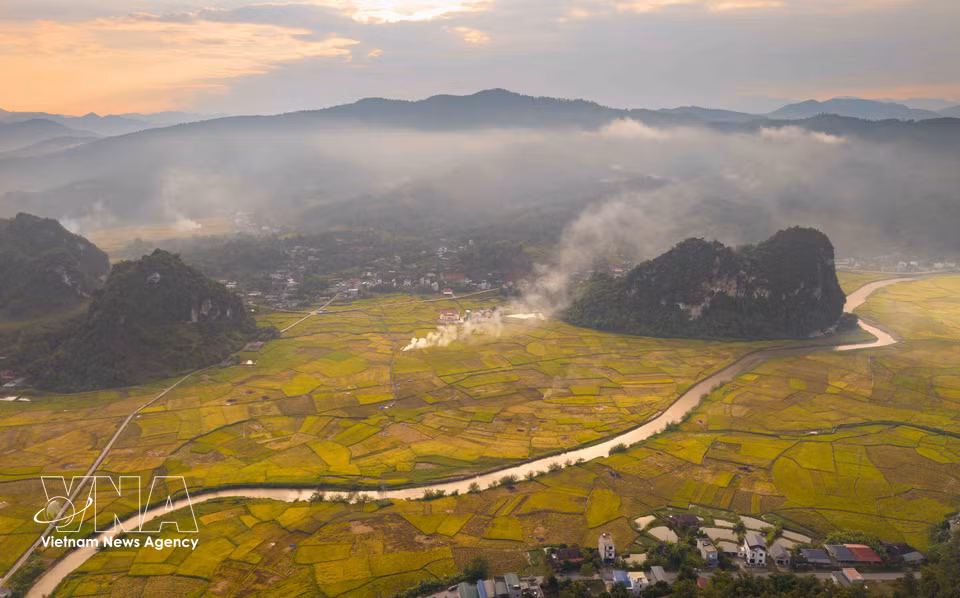 Des volutes de fumée s’élèvent au milieu des rizières baignées par les dernières lueurs du soleil, ajoutant une touche poétique au paysage doré de Chieng Sinh. Photo: VNA