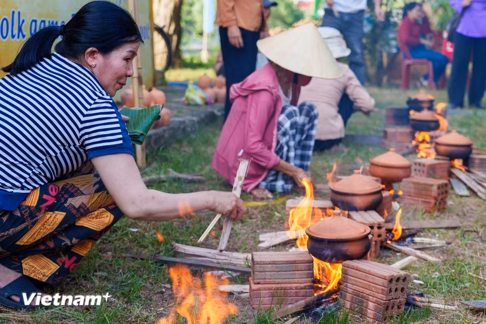 Les compétitrices ajustent avec précision l'intensité du feu de bois afin de garantir une cuisson parfaite et de préserver les saveurs du riz. Photo : Vietnam+