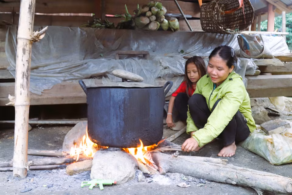 Dans le village de Bung, une femme et sa fille préparent le repas quotidien autour du foyer traditionnel de la maison. Photo : VNA