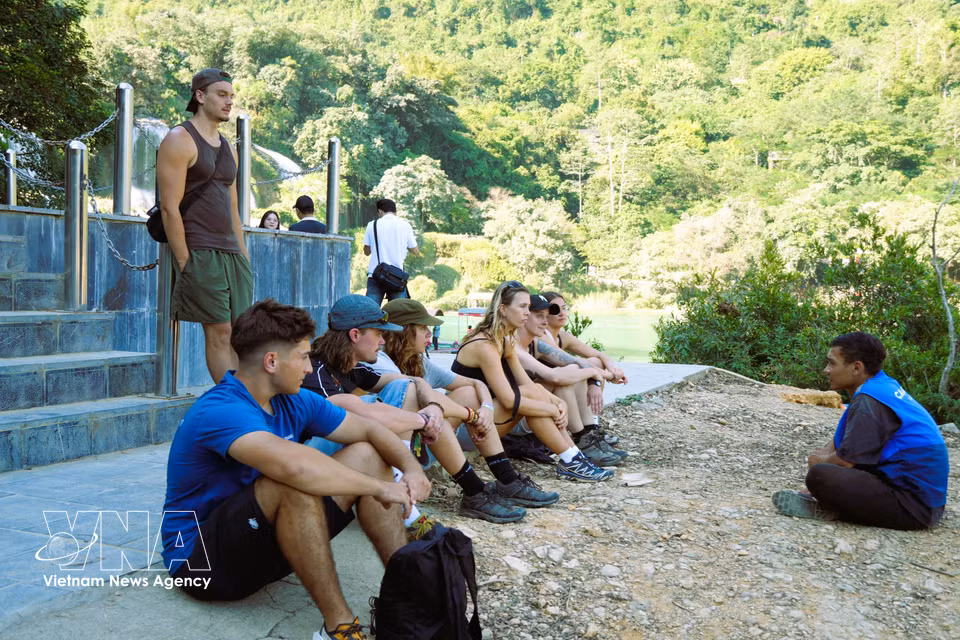 Des touristes internationaux enthousiastes explorent le site naturel de la cascade de Ban Gioc. Photo : VNA