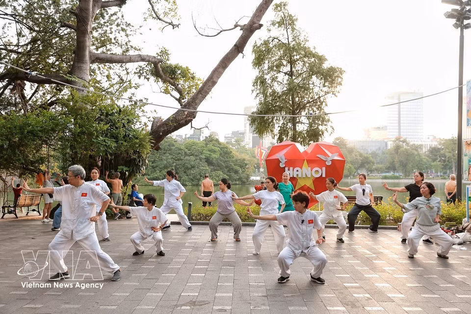 Des seniors pratiquent le Tai-chi sur les berges du lac Hoan Kiem, un rituel quotidien pour entretenir l'équilibre du corps et de l'esprit. Photo : VNA