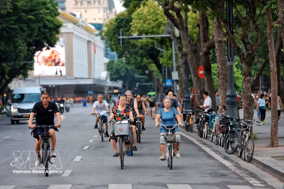 Des cyclistes du troisième âge parcourent les artères entourant le lac Hoan Kiem lors de leur entraînement matinal. Photo : VNA
