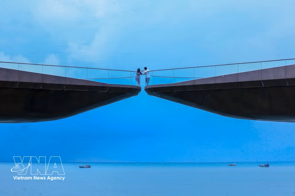 Des touristes immortalisent leur passage sur le "Pont du Baiser". Photo : VNA