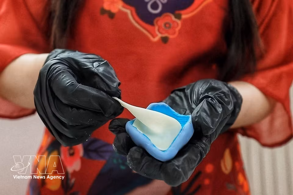 La réalisation d’une fleur de lotus repose sur un mélange traditionnel de farine de riz et de farine de riz gluant, utilisé depuis des générations pour façonner les figurines en pâte de riz. Photo : VNA