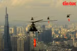 La formation d’hélicoptères militaires survolait Hô Chi Minh-Ville, avec l’un des symboles de la ville, le bâtiment Landmark 81, visible en arrière-plan. Photo : Baotintuc.vn/VNA