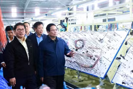 Le Premier ministre Pham Minh Chinh visite une chaîne de production d'une entreprise à Quang Nam. Photo: VNA