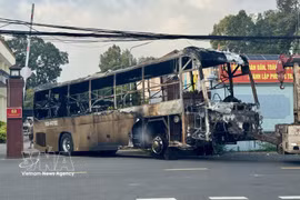 La carcasse calcinée de l'autocar est remorquée pour les besoins de l'enquête. Photo: VNA
