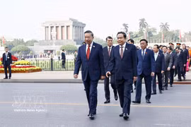 Les dirigeants du Parti et de l’État, les représentants du Front de la Patrie du Vietnam et les députés déposent des gerbes de fleurs et rendent hommage au Président Hô Chi Minh dans son mausolée. Photo: VNA